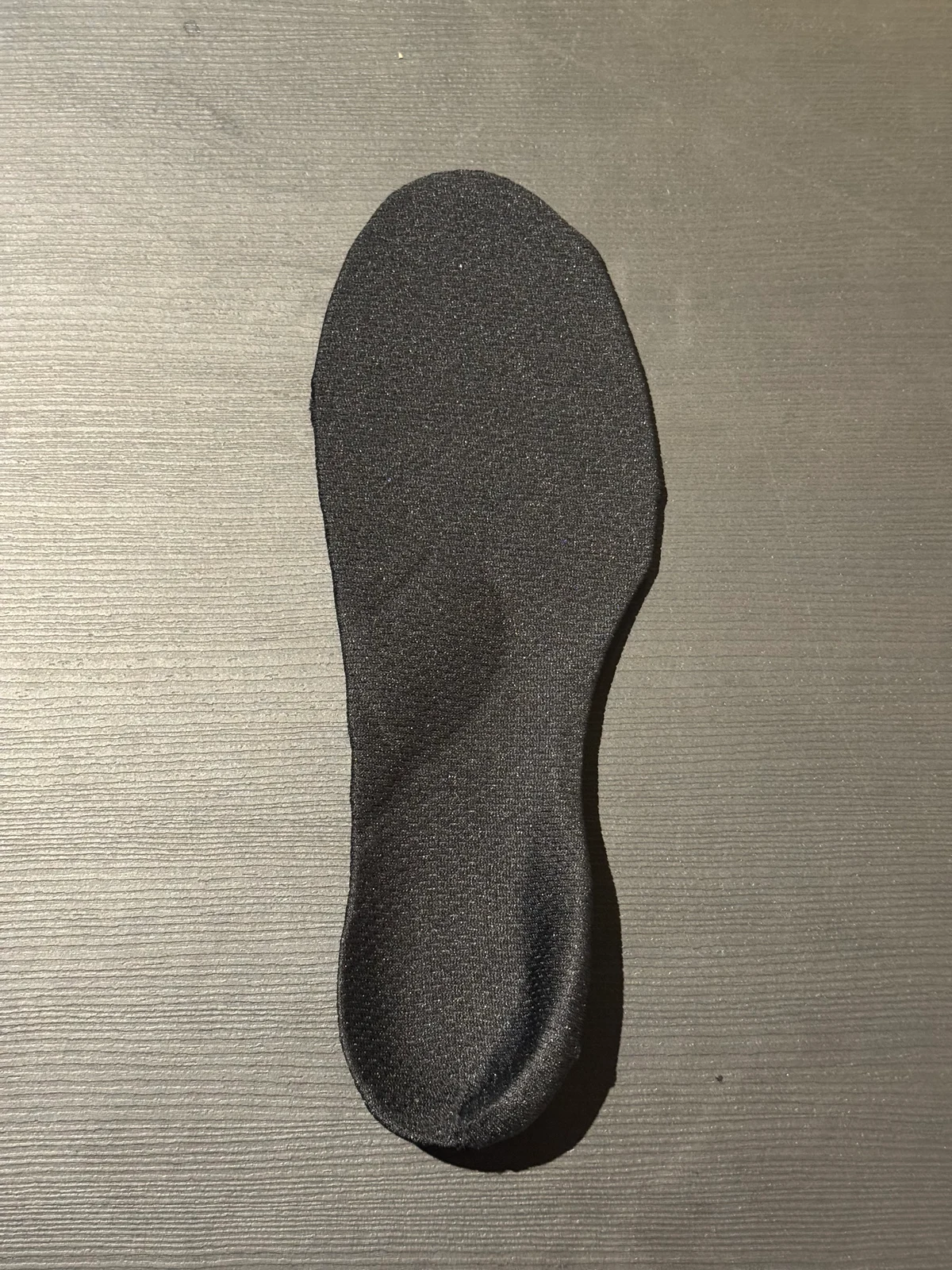 黒い仕上げシートで覆われた完成インソールの一例。片足分