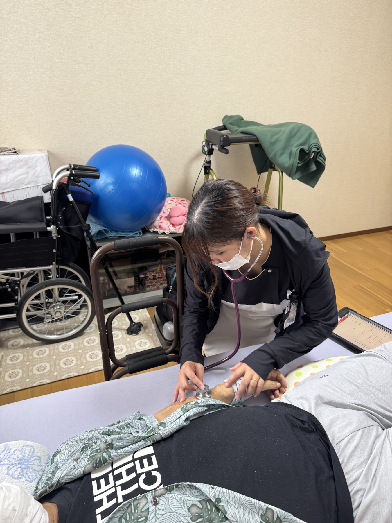 利用者の体調を聴診する訪問看護師